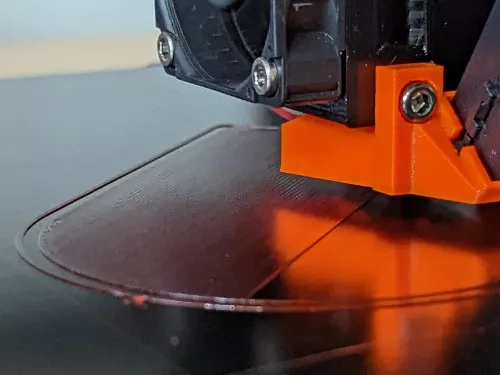 Close-up photograph of a 3D printer on its first layer.